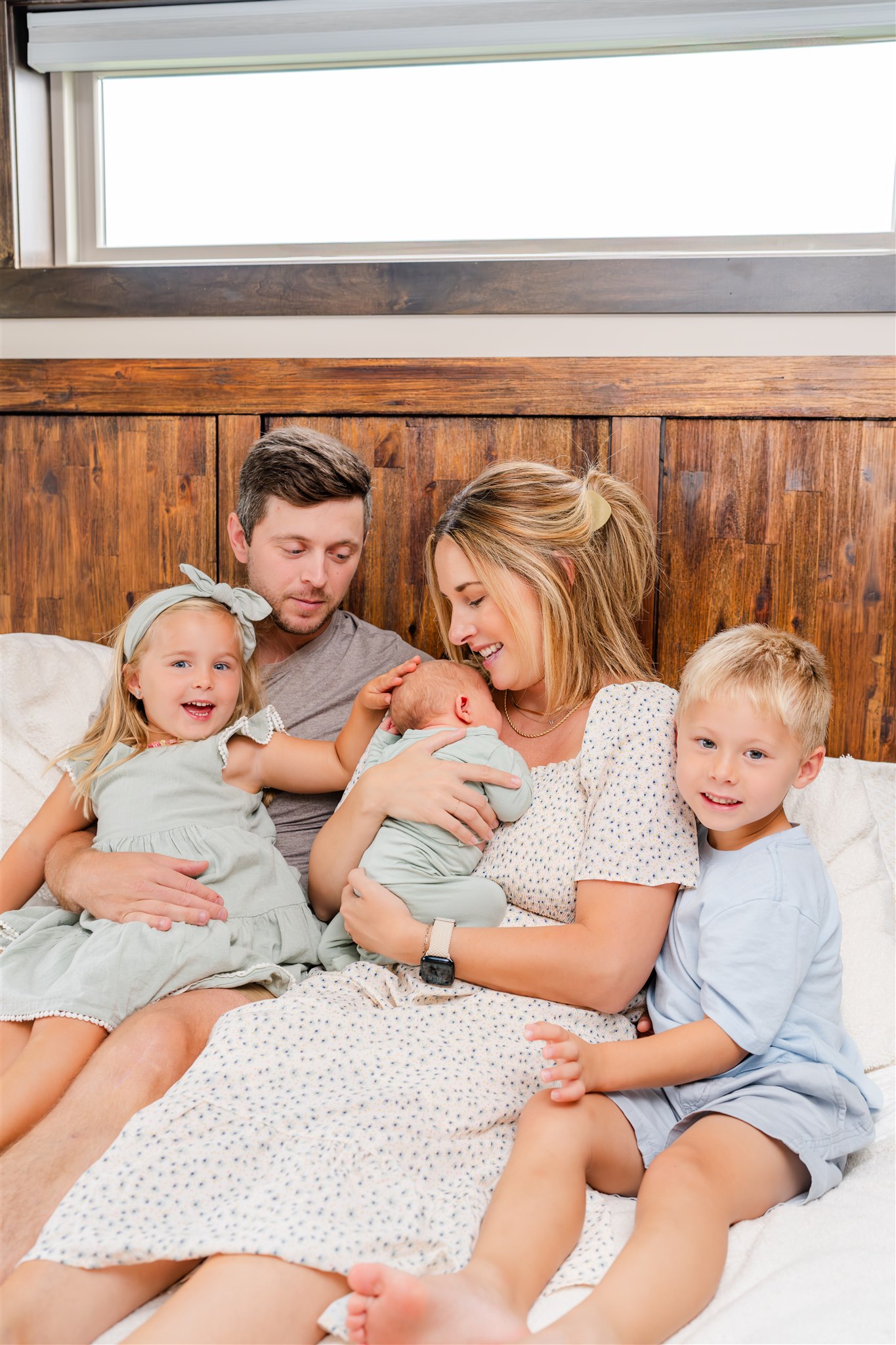 whole family on master bed during in home newborn photography session